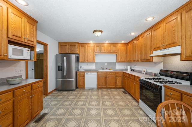 kitchen featuring white appliances, sink, a textured ceiling, and decorative backsplash