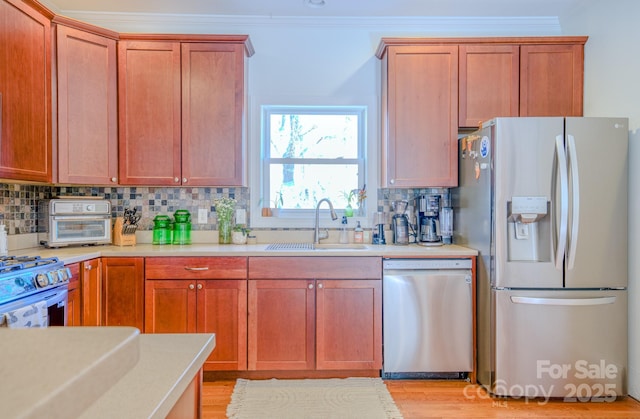 kitchen featuring stainless steel appliances, a sink, and light countertops