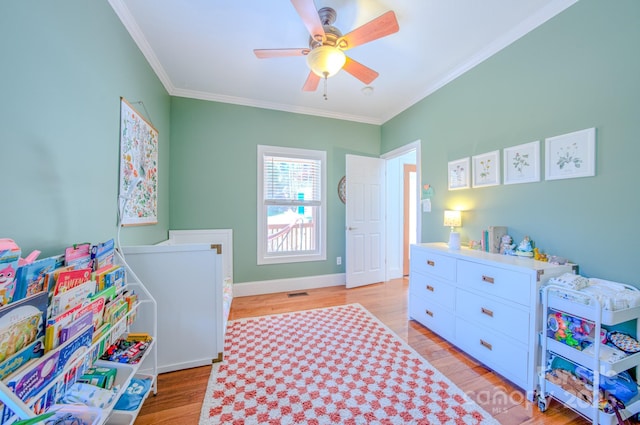 bedroom with light wood finished floors, baseboards, visible vents, and crown molding