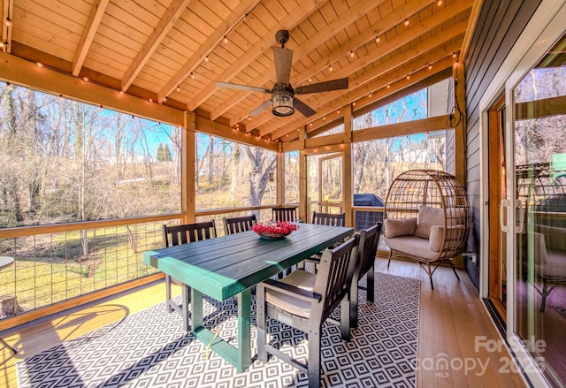 sunroom / solarium featuring a ceiling fan, wooden ceiling, and lofted ceiling with beams