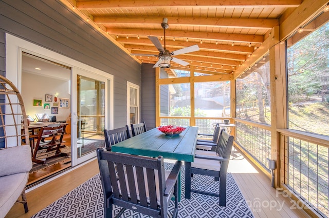 sunroom / solarium with lofted ceiling with beams, wooden ceiling, and ceiling fan