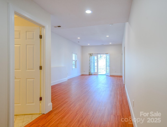 empty room with baseboards, light wood finished floors, visible vents, and recessed lighting