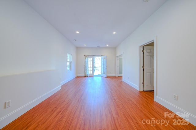 empty room featuring light wood-style flooring, baseboards, and recessed lighting