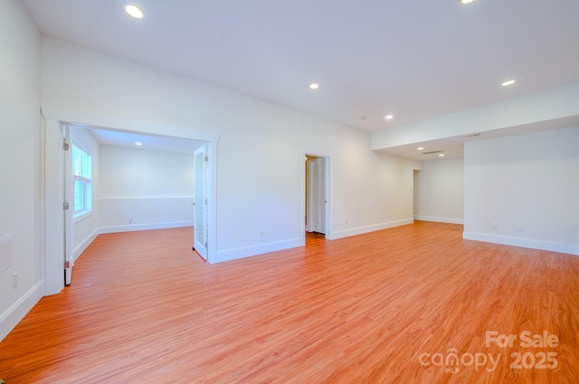 spare room featuring light wood-style flooring, baseboards, and recessed lighting