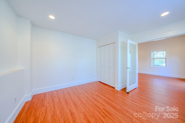 unfurnished bedroom featuring light wood finished floors, a closet, recessed lighting, and baseboards