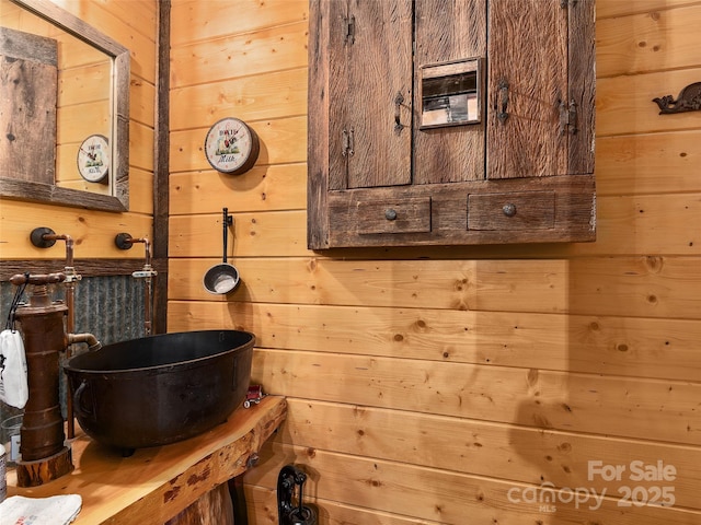 bathroom with a sink and wooden walls