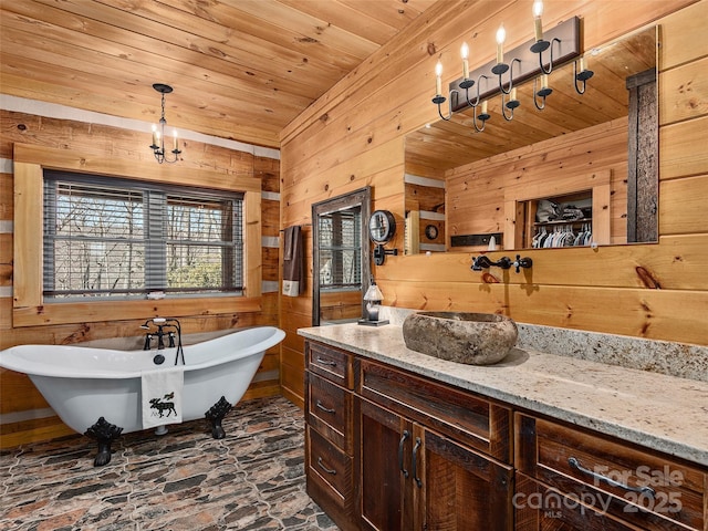 full bath featuring wooden ceiling, a freestanding tub, wooden walls, and vanity