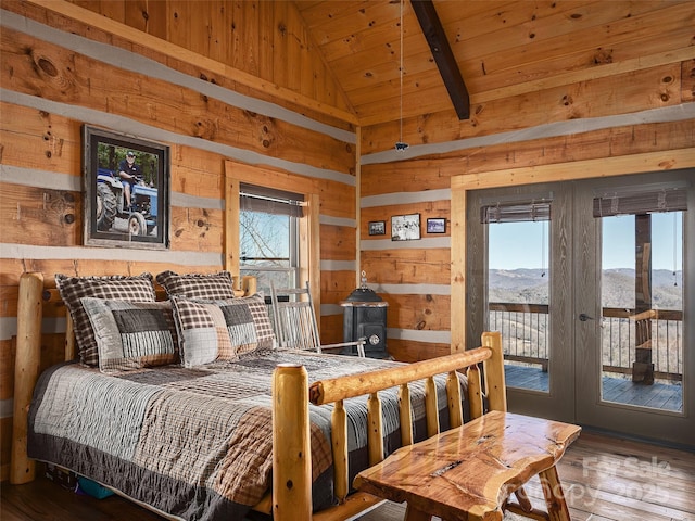 bedroom with lofted ceiling, wood ceiling, wood walls, access to outside, and multiple windows