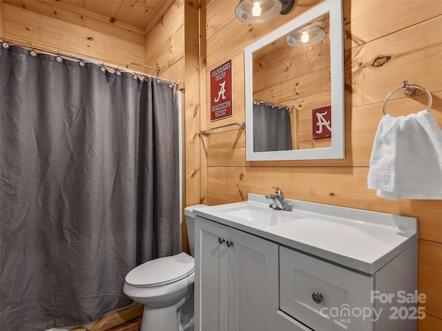 full bathroom featuring toilet, wood walls, and vanity