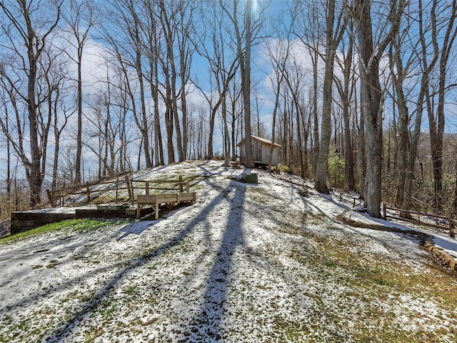 view of road with gravel driveway and a wooded view