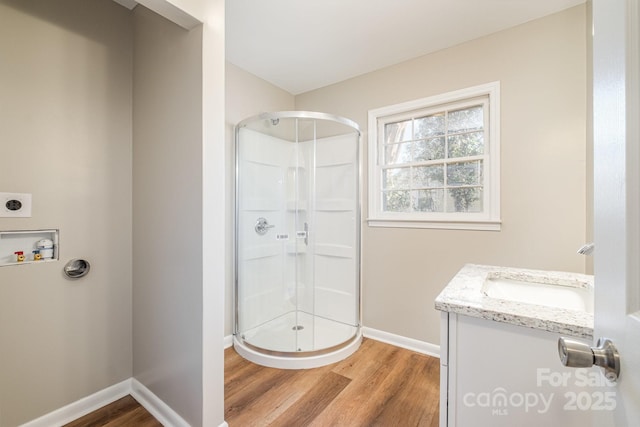 bathroom with hardwood / wood-style flooring, vanity, and a shower with door