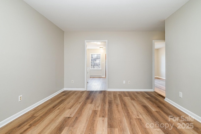 unfurnished room with light hardwood / wood-style floors and a baseboard radiator