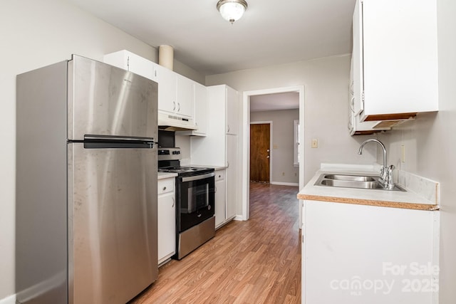 kitchen with light wood-type flooring, appliances with stainless steel finishes, white cabinetry, and sink