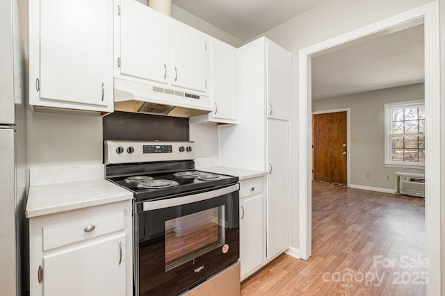 kitchen with stainless steel range with electric stovetop, light hardwood / wood-style floors, a wall mounted air conditioner, fridge, and white cabinetry