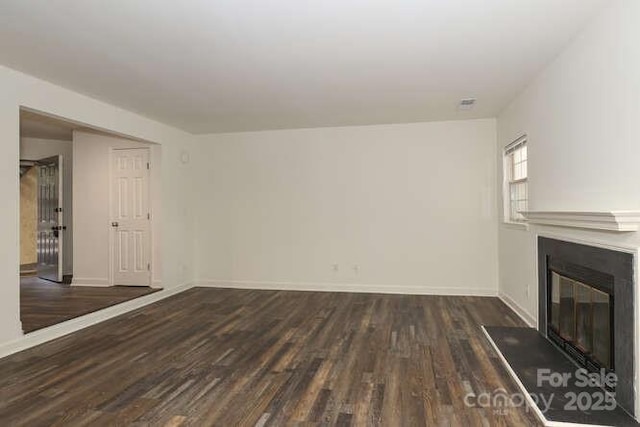 unfurnished living room with dark wood-type flooring