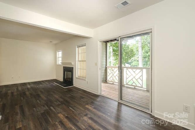 unfurnished living room with dark wood-type flooring and beamed ceiling