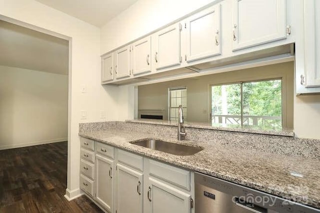 kitchen with light stone counters, sink, and white cabinets