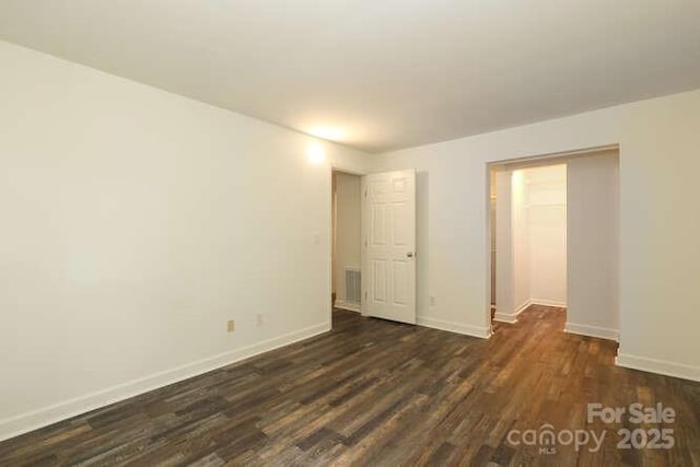 unfurnished room with dark hardwood / wood-style flooring