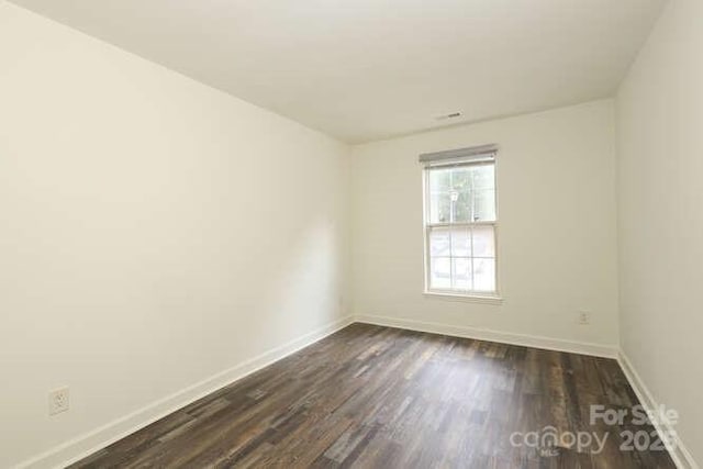 unfurnished room featuring dark wood-type flooring