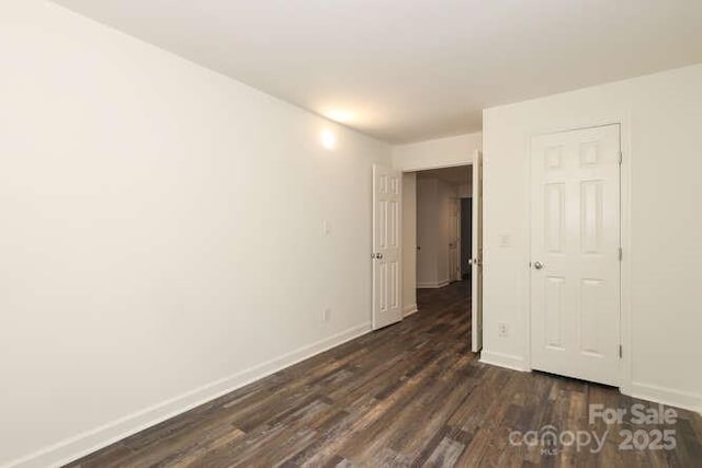 unfurnished bedroom with dark hardwood / wood-style flooring