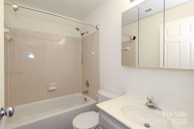 full bathroom featuring tiled shower / bath, vanity, and toilet