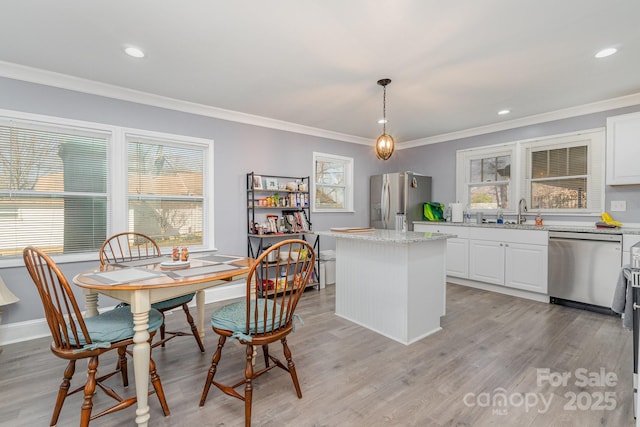 interior space featuring white cabinets, a center island, pendant lighting, and stainless steel appliances