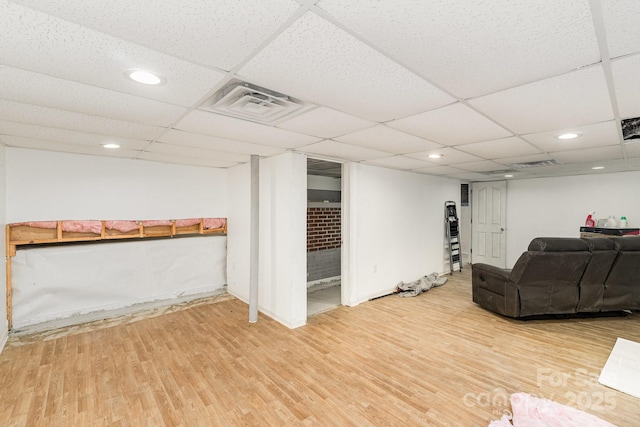 living room featuring a paneled ceiling and wood-type flooring