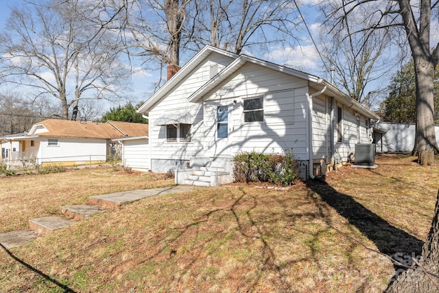 view of front of house with a front lawn and central air condition unit