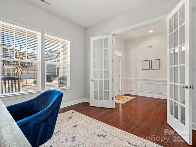 office with a decorative wall, french doors, a wainscoted wall, and wood finished floors