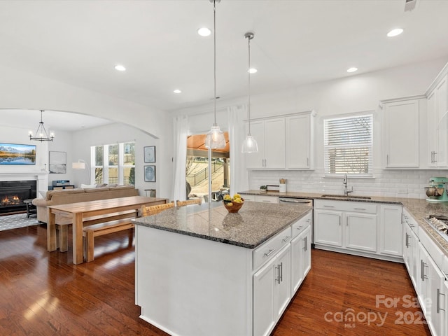 kitchen featuring plenty of natural light, open floor plan, backsplash, and a sink