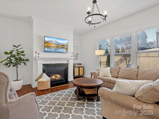 living room featuring a glass covered fireplace, plenty of natural light, baseboards, and wood finished floors