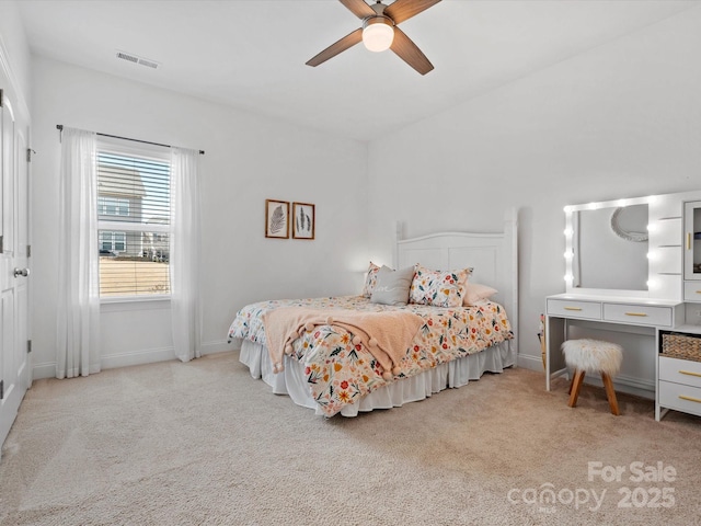 carpeted bedroom with visible vents, baseboards, and a ceiling fan