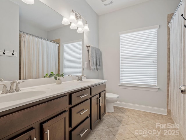 full bath with a sink, toilet, double vanity, and tile patterned flooring