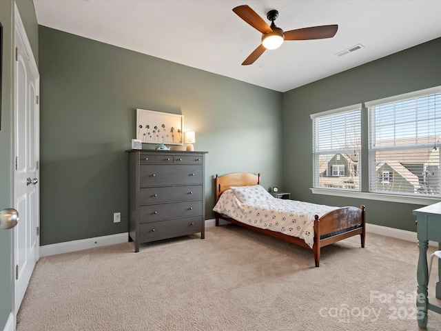 carpeted bedroom featuring baseboards, visible vents, and ceiling fan