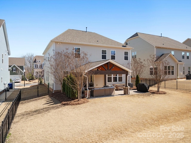 rear view of property featuring a fenced backyard, a shingled roof, outdoor lounge area, a patio area, and a residential view