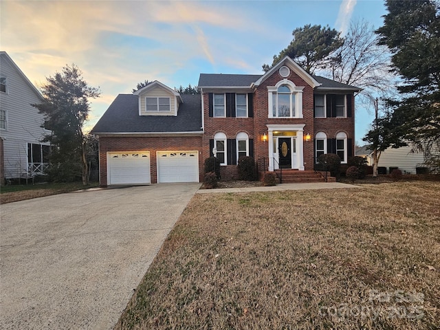 colonial-style house with a garage and a yard