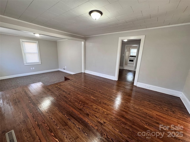 unfurnished room with ornamental molding, a healthy amount of sunlight, and dark hardwood / wood-style floors