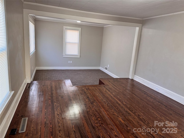 unfurnished room featuring ornamental molding and dark wood-type flooring