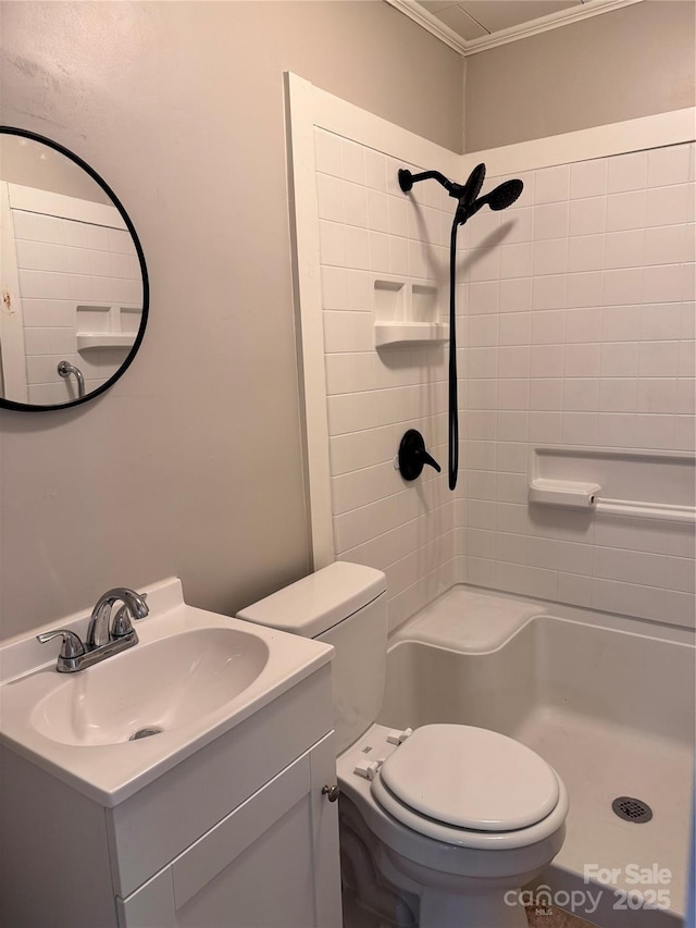 bathroom with tiled shower, vanity, and toilet