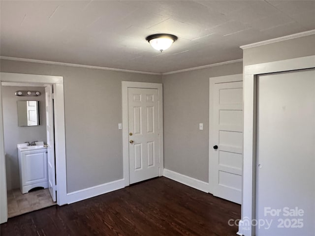 unfurnished bedroom with dark wood-type flooring, crown molding, and a closet