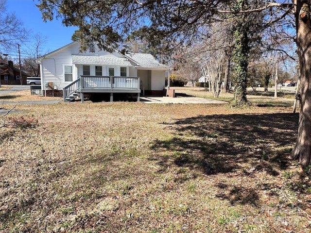 view of front of home featuring a front lawn and a deck