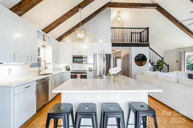 353 Whippoorwill Rd, Mooresville, NC 28117 - kitchen featuring stainless steel appliances, a sink, high vaulted ceiling, a breakfast bar, and beamed ceiling