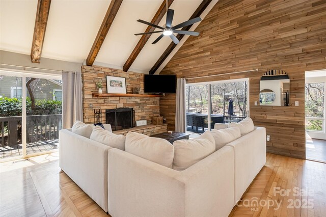 353 Whippoorwill Rd, Mooresville, NC 28117 - living area with high vaulted ceiling, wood walls, beamed ceiling, a ceiling fan, and a fireplace
