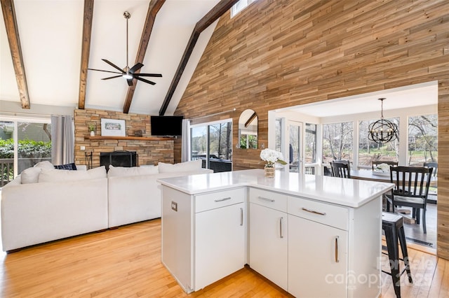 353 Whippoorwill Rd, Mooresville, NC 28117 - kitchen with high vaulted ceiling, open floor plan, a fireplace, ceiling fan, and light countertops