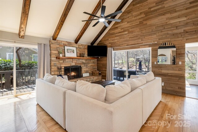 353 Whippoorwill Rd, Mooresville, NC 28117 - living area with high vaulted ceiling, wood walls, ceiling fan, a fireplace, and beamed ceiling