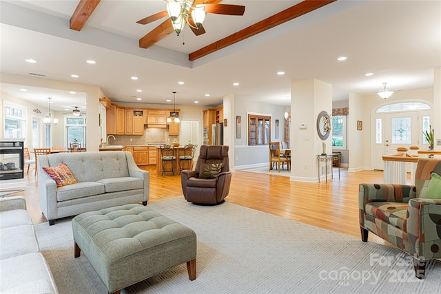 living room featuring light wood finished floors, baseboards, beam ceiling, and recessed lighting