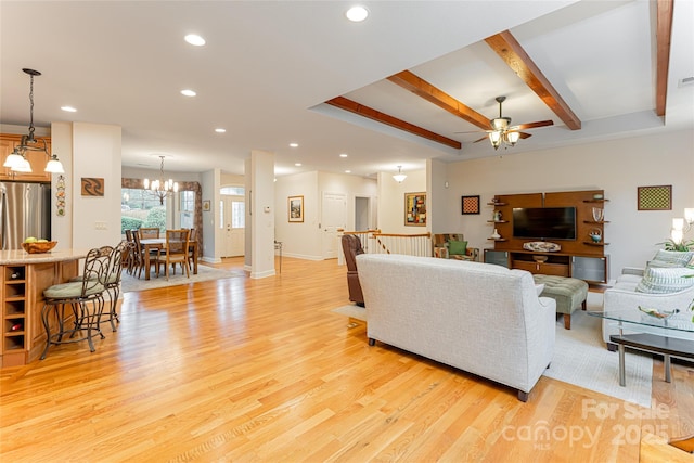 living room with ceiling fan with notable chandelier, light wood-type flooring, beam ceiling, and recessed lighting