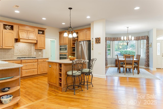 kitchen featuring a kitchen island, light countertops, appliances with stainless steel finishes, open shelves, and pendant lighting