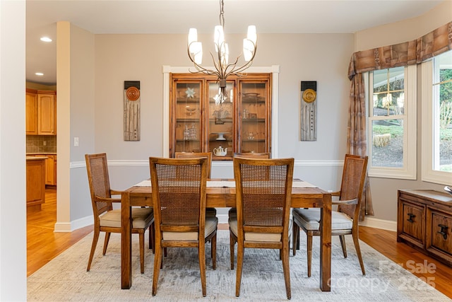 dining space featuring a notable chandelier, recessed lighting, baseboards, and light wood-style floors