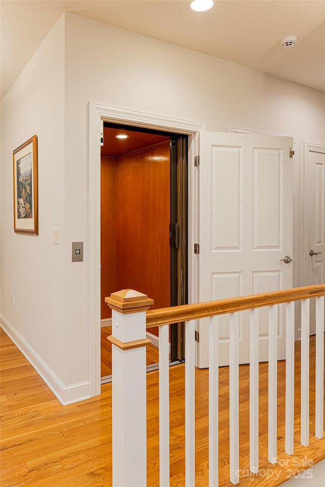 corridor with recessed lighting, light wood-style flooring, and baseboards